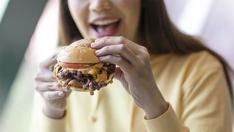 photo of a woman holding a hamburger
