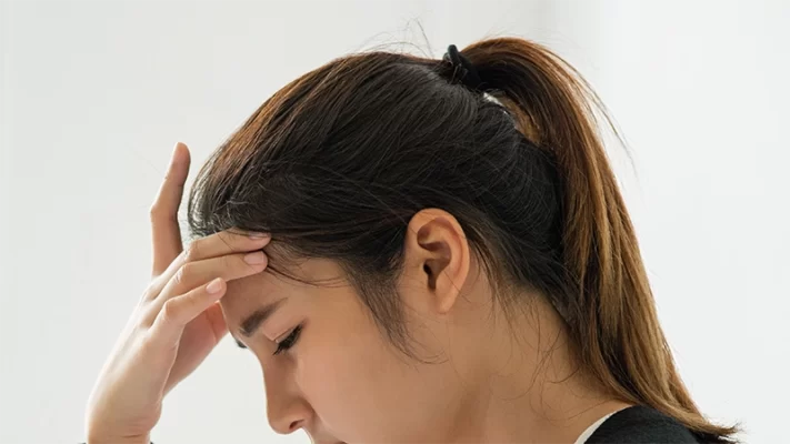 photo of a woman having headaches