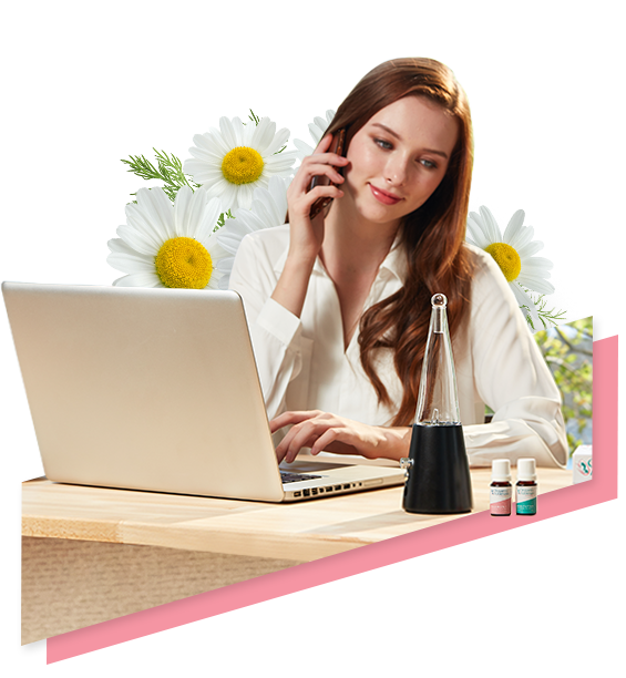 A woman sitting at a desk with flowers and a laptop engages in work with her diabetes management.