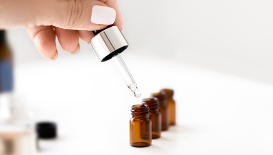 A variety of essential oils in small bottles on a wooden surface