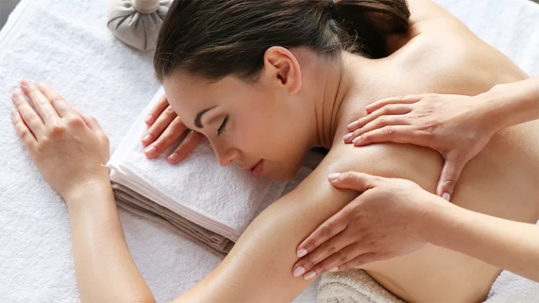 beautiful woman receiving massage therapy with essential body oils