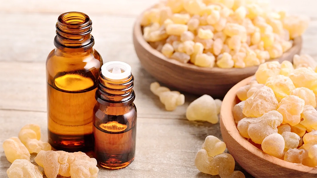 A couple of bottles of Frankincense essential oil surrounded by Frankincense in a bowl