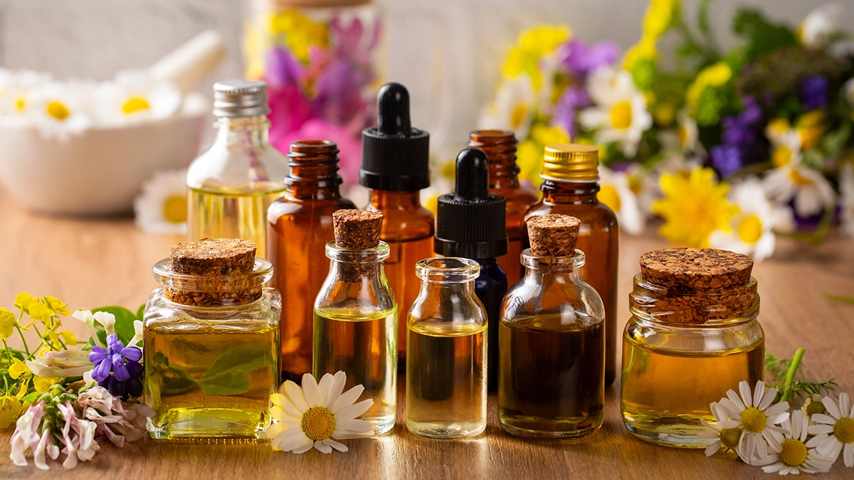  A variety of essential oil bottles with fresh flowers, highlighting natural remedies for hemorrhoids