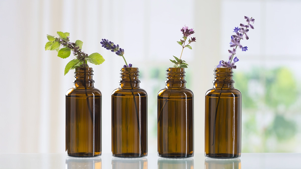 Amber bottles with various herbs, showcasing essential oils known for repelling cockroaches