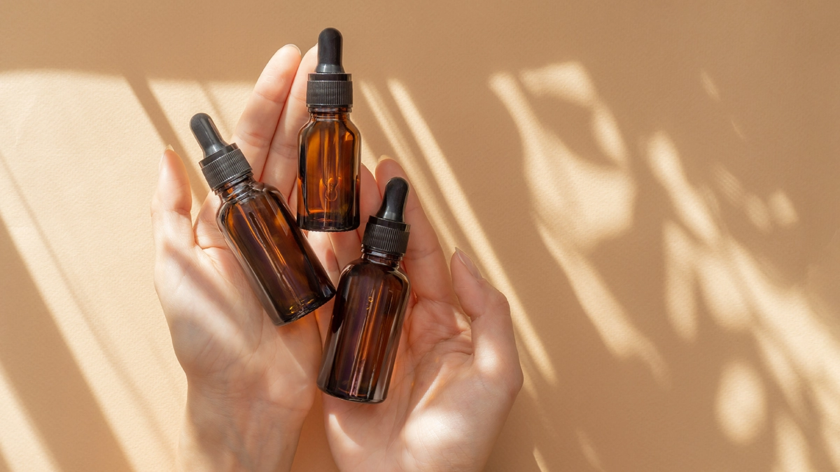 Hands holding essential oil bottles for lupus relief