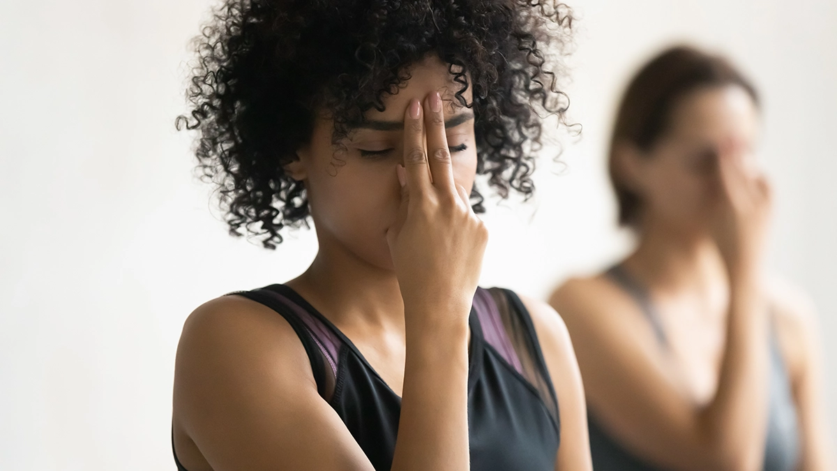 Two women practice breathing exercises while focusing on their Third Eye Chakra, symbolizing intuition and spiritual awareness