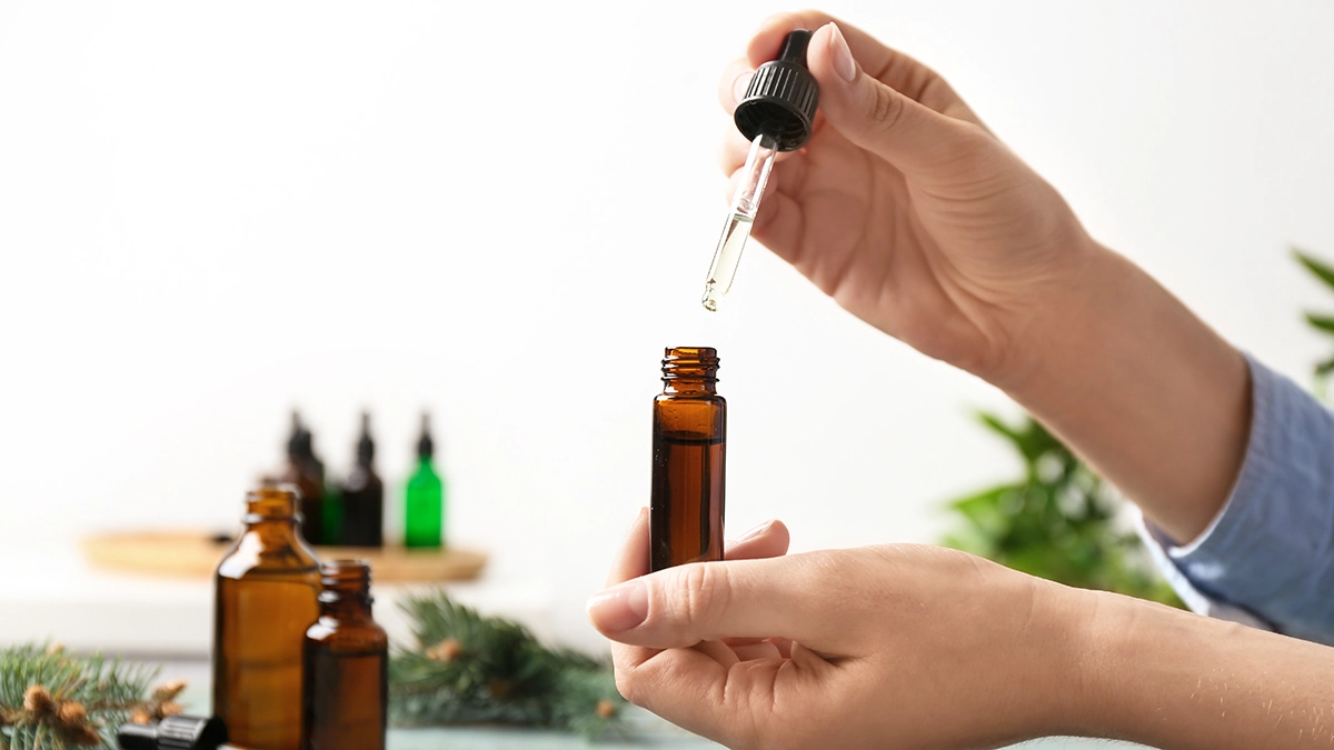 Hands using a dropper with essential oils, known for relieving congestion