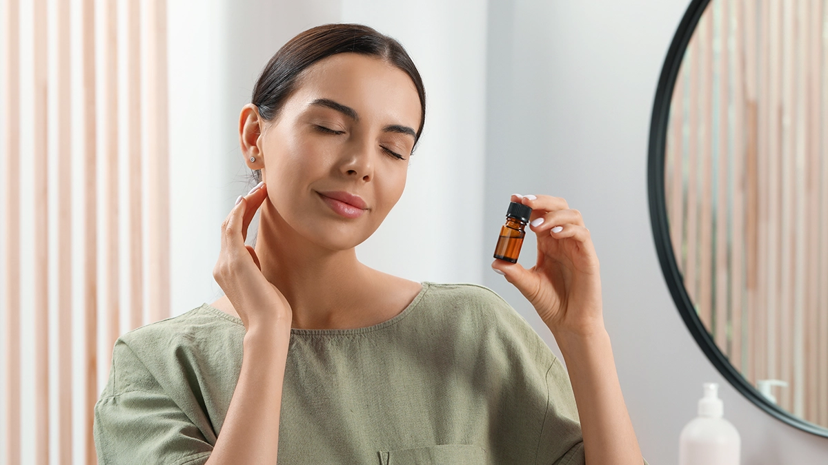 Woman holding essential oil bottle, applying it for congestion relief