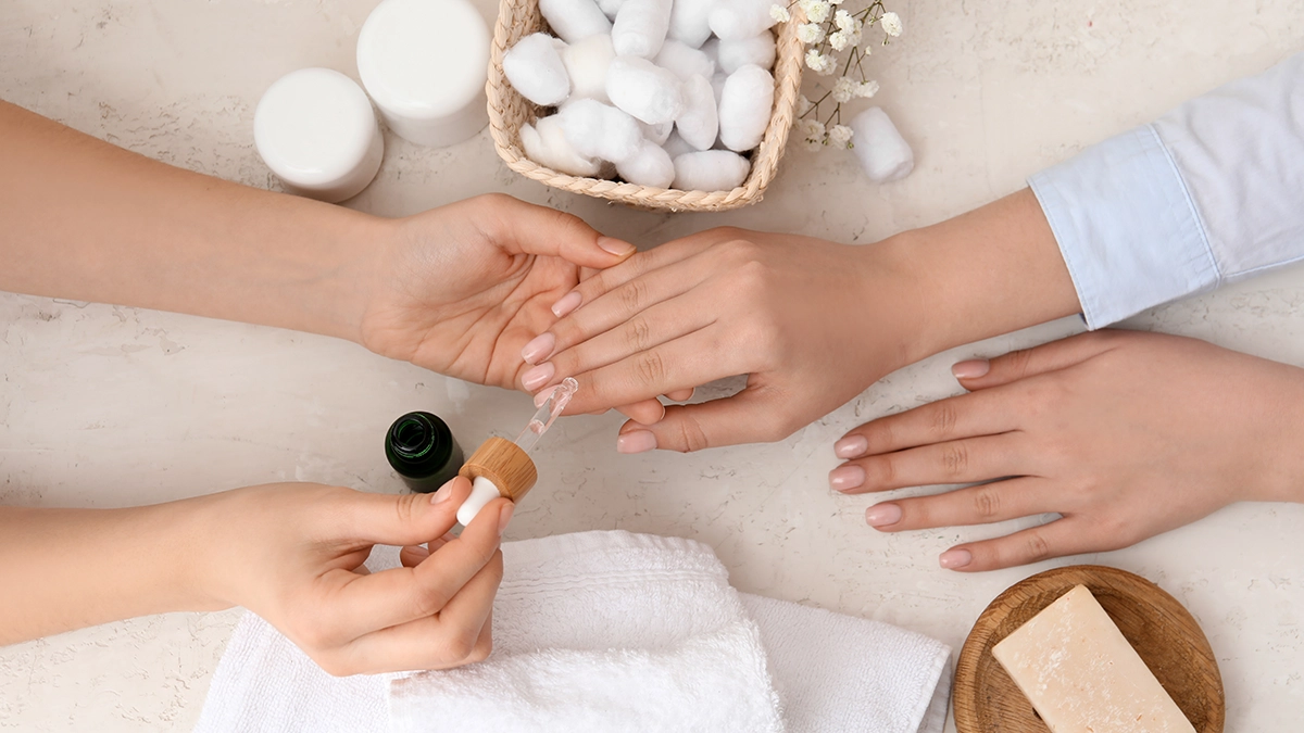 Applying essential oil to nails, highlighting its benefits for soothing ingrown fingernails