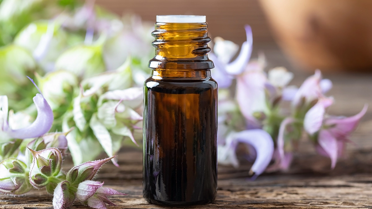 Clary sage oil bottle with flowers, aiding relaxation and labor