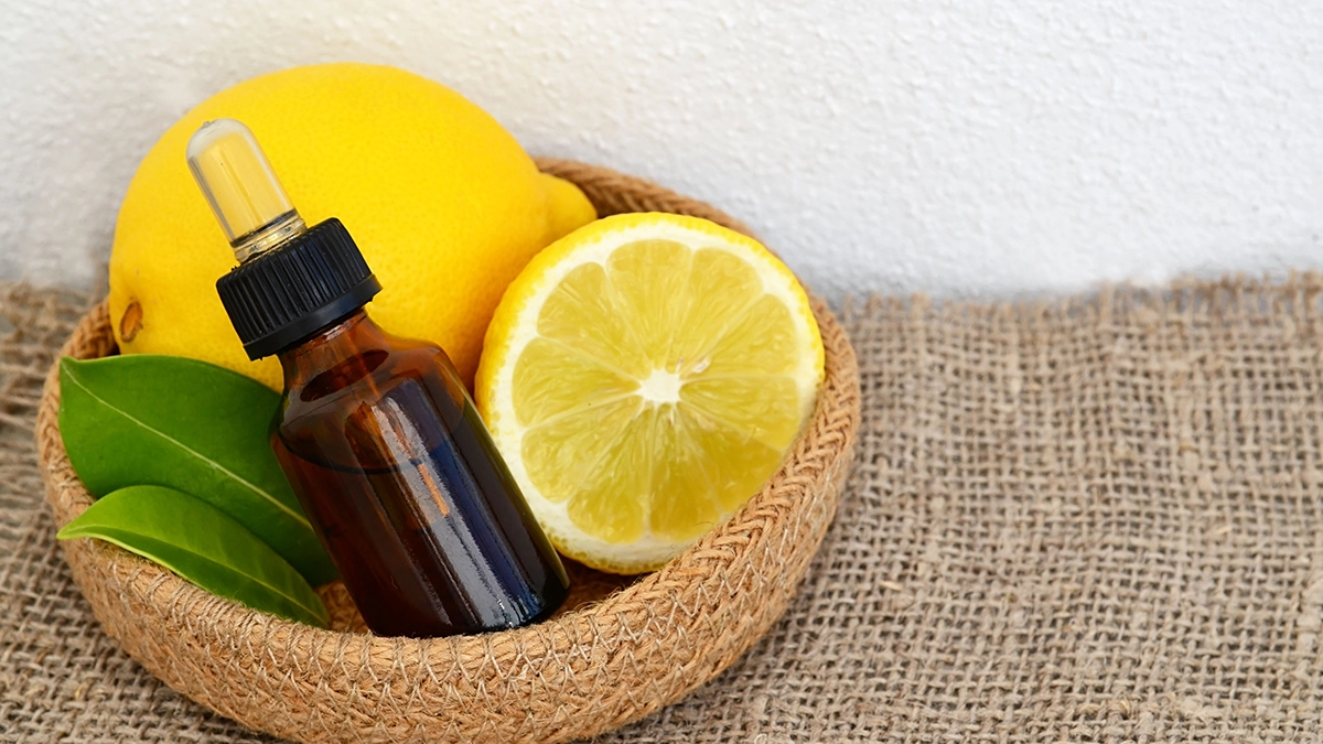 Essential oil bottle with lemons and leaves in a woven basket