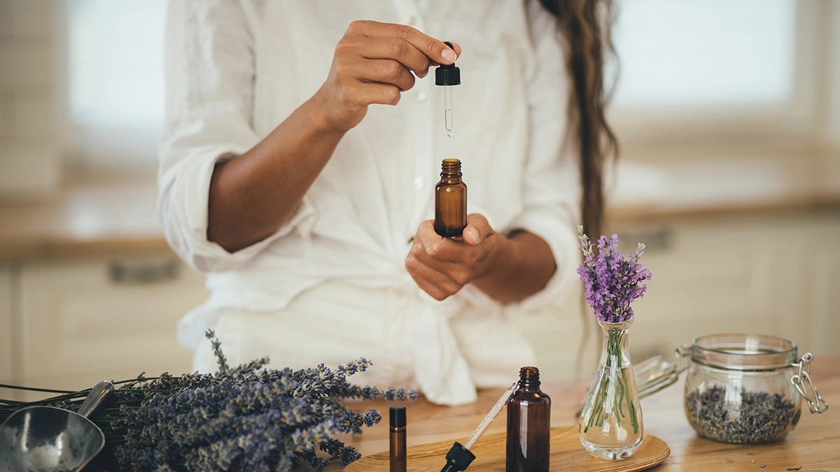 Person handling essential oils with lavender, related to repelling fruit flies